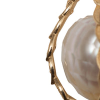 closeup of the faceted pearl and the gold leaves