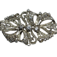 front view of the brooch with flowing ribbon/ bow motif