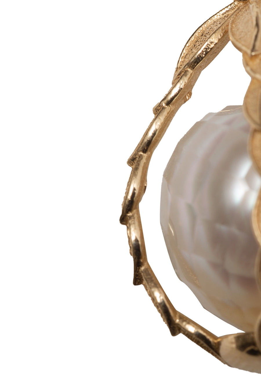 closeup of the faceted pearl and the gold leaves 