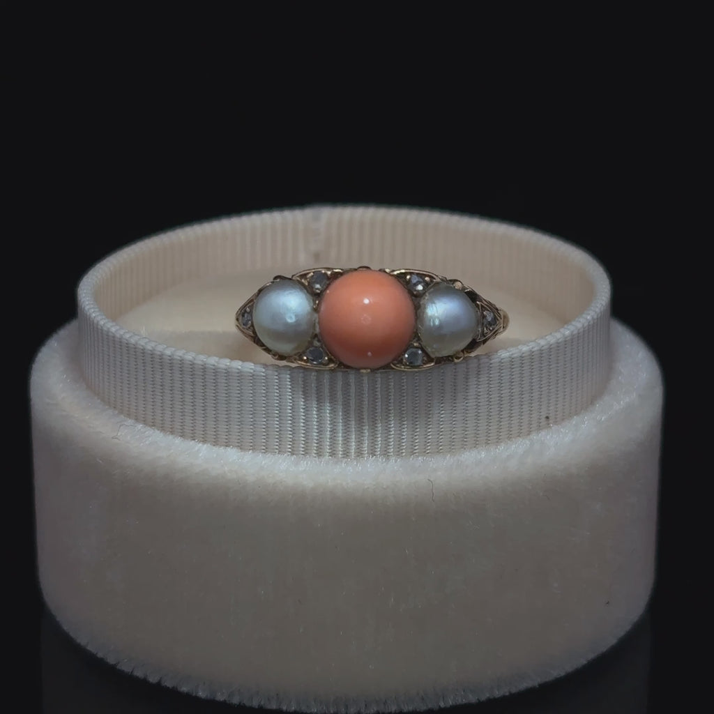 showing the top of the ring: the coral, two pearls, and diamonds 